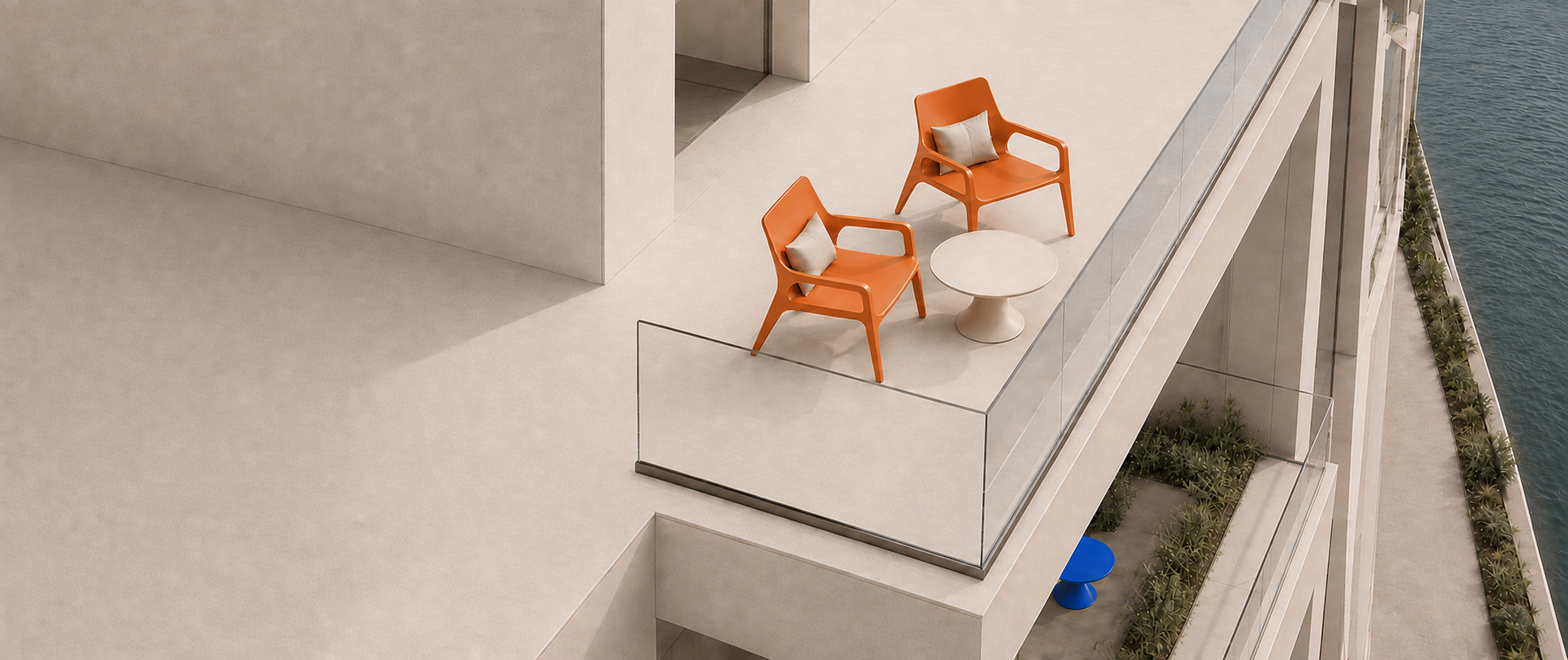 Two terracotta monobloc lounge chairs and an ivory table on a waterfront terrace; a blue table is visible below
